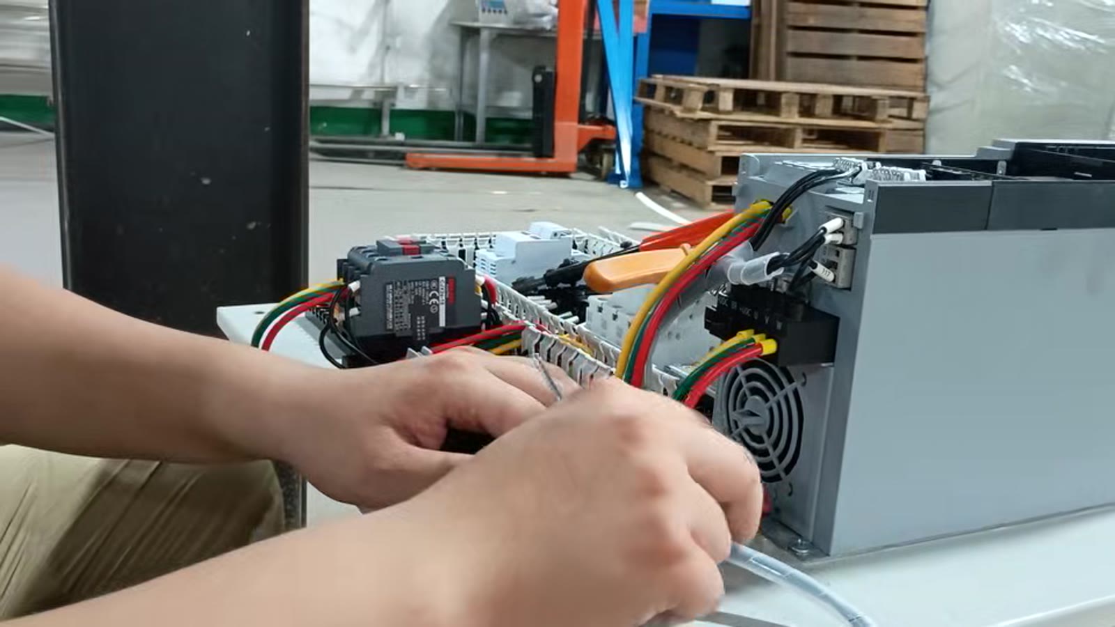 Technician wiring a smoke exhaust fan control unit